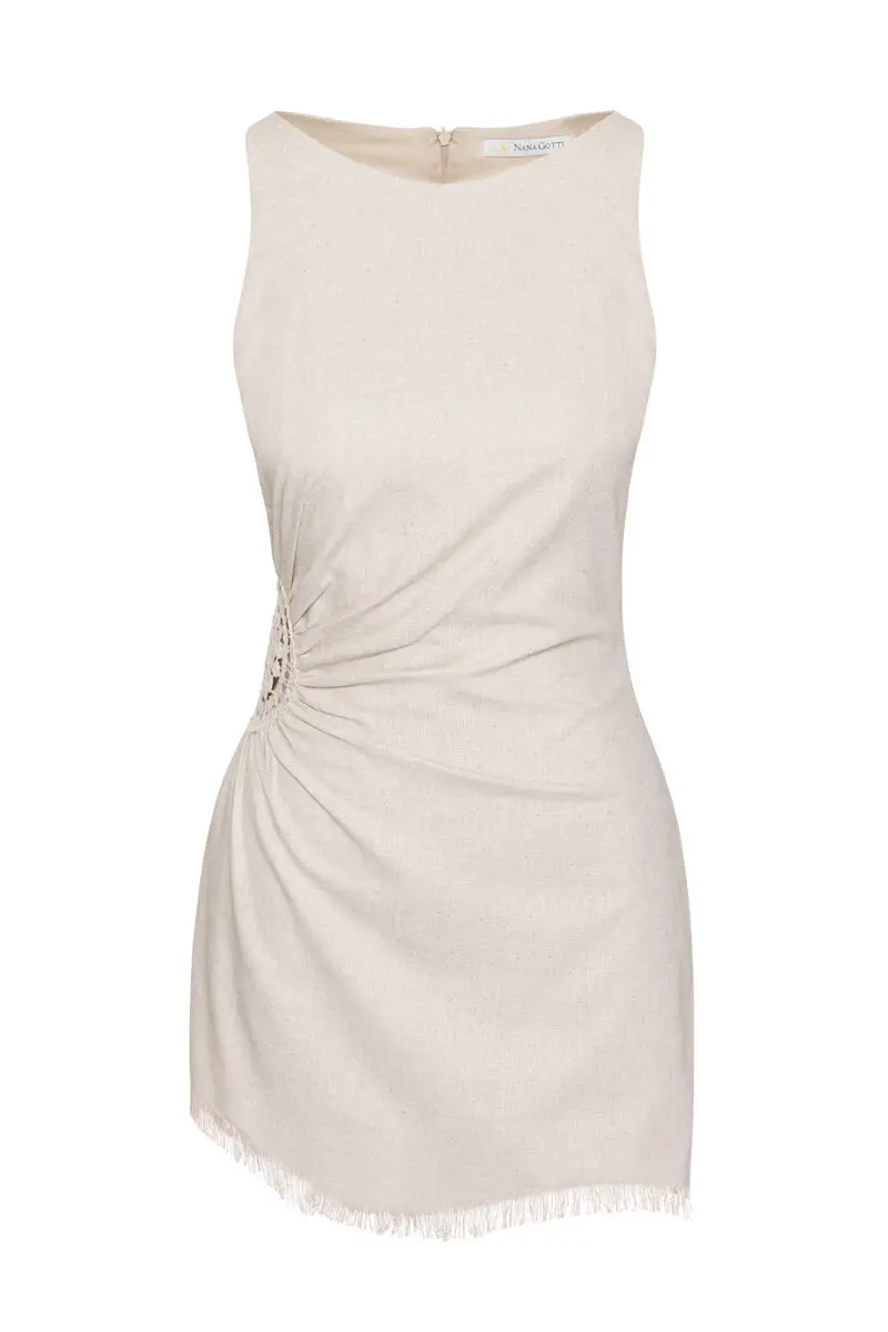 This dress is a sleeveless, natural beige mini-dress made from a lightweight fabric. It features a gathered, ruched detail at the side with an open crochet accent, adding a unique and stylish texture. The bottom hem has a delicate fringe trim, giving the dress a relaxed, bohemian vibe. The simple round neckline and fitted silhouette highlight its minimalistic yet elegant design, perfect for casual or semi-formal summer wear.