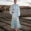 Ege Ruched Chiffon Fringe Midi Dress by Nana Gotti featuring a high neckline, voluminous sleeves, fitted waist, and cascading blue fringe hem.