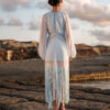 Back view of Nana Gotti Ege Fringe Midi Dress in pastel blue with sheer chiffon sleeves, ruched back, and flowing fringe detailing.